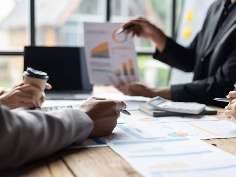 Business team analyzing charts and graphs at a meeting table.
