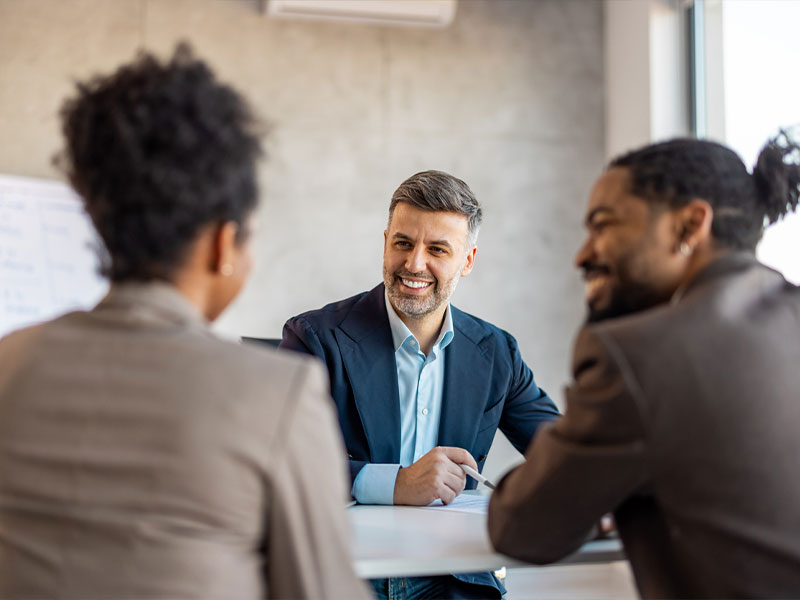 Business meeting with three professionals in a modern office setting.