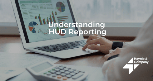 Person analyzing financial charts on a laptop with Understanding HUD Reporting text and Haynie logo.