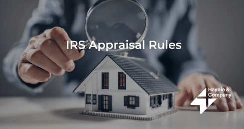 Man inspecting model house under magnifying glass, IRS appraisal rules, Haynie branding.