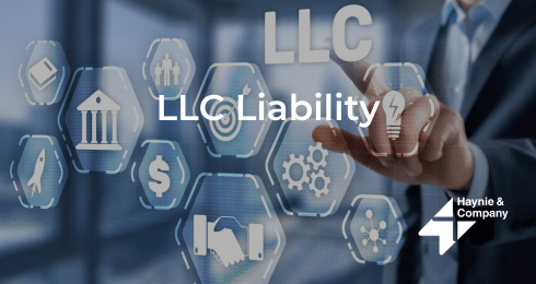 Businessman interacting with virtual LLC liability icons on a screen.