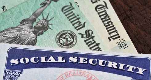 Social Security card and U.S. Treasury checks on a wooden surface.