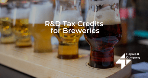 Flight of beers on a wooden tray with text about R&D Tax Credits for Breweries from Haynie.