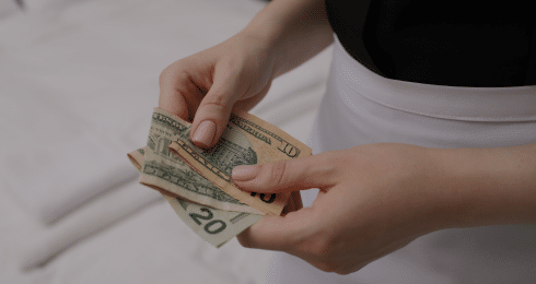 Person counting US dollar bills, financial transactions concept.