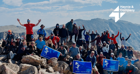 Group of people on a mountain hike holding Haynie banners.