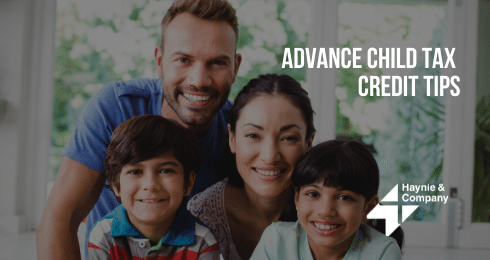 Family smiling at camera with Advance Child Tax Credit Tips and Haynie logo.