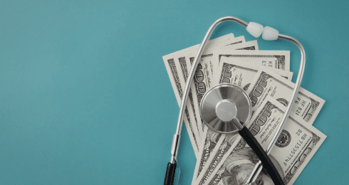 Stethoscope and dollar bills on a teal background, symbolizing healthcare costs or medical finance.