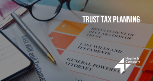 Trust tax planning documents with glasses and pen from Haynie.
