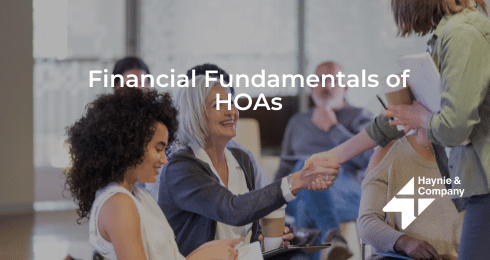 Group discussing financial fundamentals of HOAs with handshake in a meeting.
