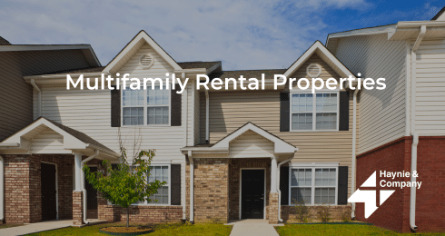 Multifamily rental properties with Haynie logo, featuring modern townhouses under a blue sky.