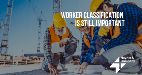 Construction workers reviewing plans at a building site with cranes in the background.