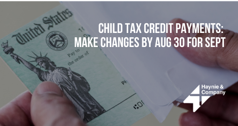 Hands holding a U.S. Treasury check with a message on child tax credit payments and deadline.