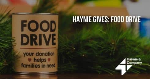 Food drive donation can with Haynie logo and holiday greenery.