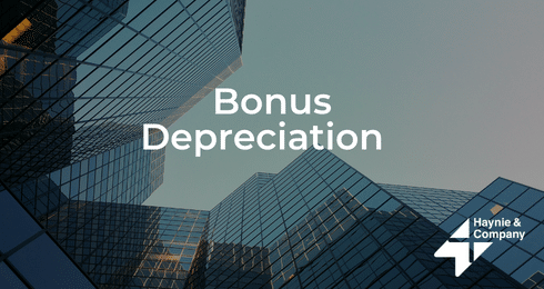 Bonus Depreciation text over modern glass skyscrapers, Haynie logo visible.