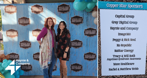 Haynie event backdrop with two women posing and sponsor list displayed.