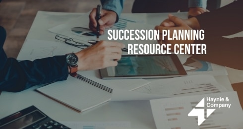 Two people discussing documents at a table with Succession Planning Resource Center text.