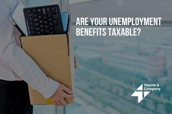 Person holding box with keyboard, text: Are your unemployment benefits taxable? Haynie logo visible.