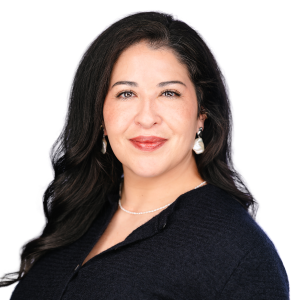 A woman with long dark hair, wearing earrings and a dark top, smiling at the camera against a white background.