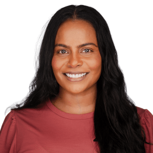 A woman smiling in a red top with a white background.