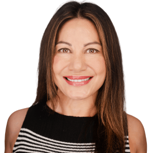 A smiling woman with long hair wearing a black and white striped top on a white background.
