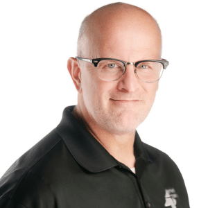Bald man with glasses and black shirt, smiling slightly, white background.