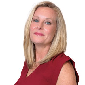 A person with blonde hair wearing a red top, looking at the camera against a white background.
