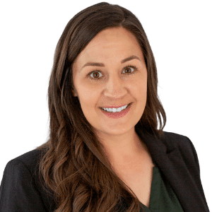 A person smiling in a professional outfit against a white background.