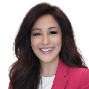 A woman smiling in a pink blazer against a white background.